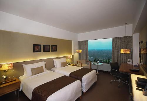 una camera d'albergo con due letti e una grande finestra di Fortune Select SG Highway, Ahmedabad - Member ITC's Hotel Group a Ahmedabad