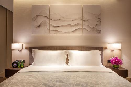 a bedroom with a bed with two white pillows at Ascott Raffles City Shenzhen in Shenzhen