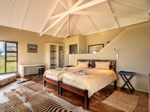 a bedroom with two beds and a zebra rug at Progress Guest Farm 