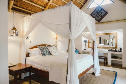 a bedroom with a bed with a canopy at Amanzi Lodge in Harare