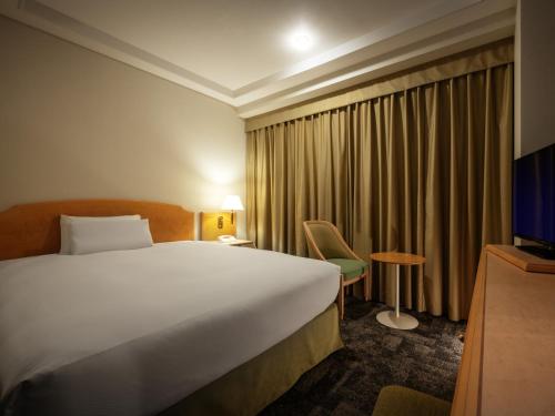 a hotel room with a bed and a television at Hotel JAL City Aomori in Aomori
