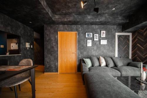 a living room with a couch and a wooden door at LUCENT in Toyohira