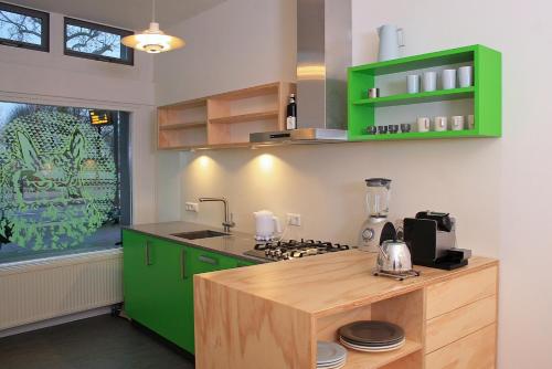 een keuken met groene kasten en een aanrecht bij B&B Central Park in Utrecht