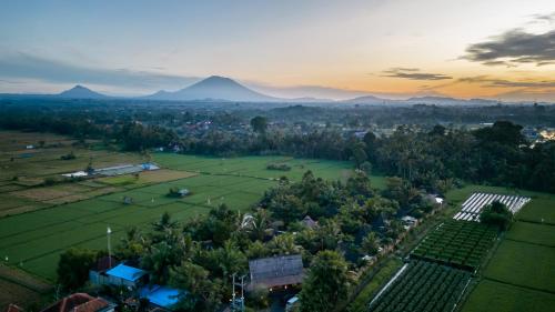 une vue aérienne sur un village avec des montagnes en arrière-plan dans l'établissement Arya Villas Ubud, à Ubud