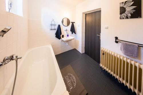 a bathroom with a bath tub and a sink at Ubytovanie U Učiteľky 