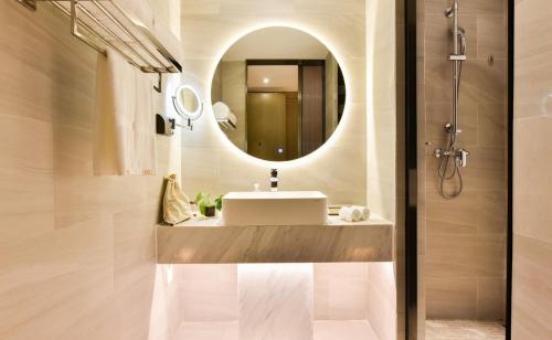 uma casa de banho com um lavatório e um espelho em Atour Hotel Beijing Fuxingmen em Pequim