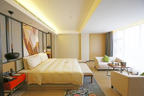 Habitación de hotel con cama grande y sofá en Atour S Hotel Chengdu Taikoo Li, en Chengdú