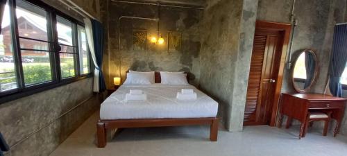 - une chambre avec un lit, une table et une chaise dans l'établissement Khwaithai Resort & Homestay - ควายไทย, 