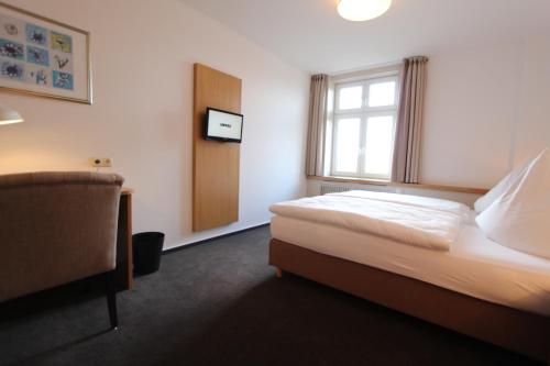 a hotel room with a bed and a window at Hotel Thormählen in Lübeck