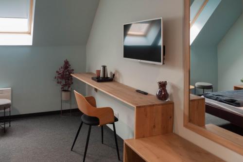 a room with a desk and a tv on a wall at Bornemisza Kúria Wellness Resort in Tiszabecs