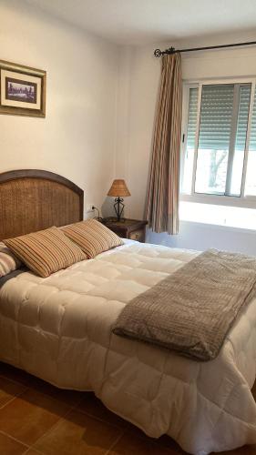 duże łóżko w sypialni z oknem w obiekcie APARTAMENTO EL PEÑON w mieście La Iruela