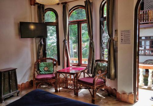 um quarto com cadeiras e janelas num quarto em Mut Mee Garden Guest House em Nong Khai