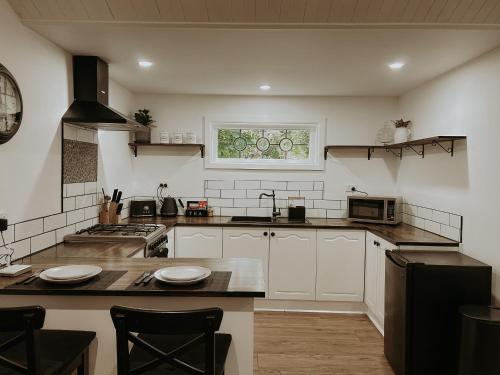 una cocina con armarios blancos y una ventana en Misty Mountain Retreat, en Olinda