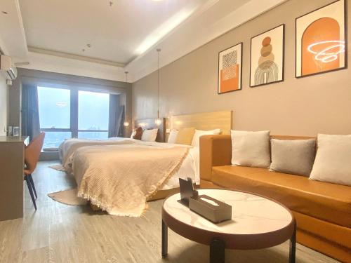 a hotel room with a bed and a couch at Guangzhou City Inn Hotel Apartment Changgang in Guangzhou