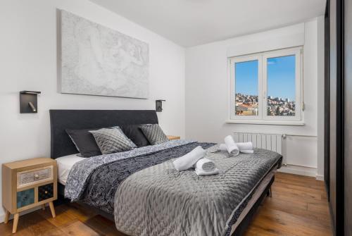 een slaapkamer met een bed met twee handdoeken erop bij Aenei Delux in Rijeka