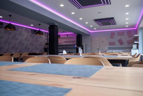 a room with tables and chairs and purple lighting at Bornemisza Kúria Wellness Resort in Tiszabecs