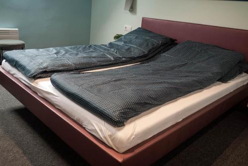 a bed with two blankets on top of it at Bornemisza Kúria Wellness Resort in Tiszabecs