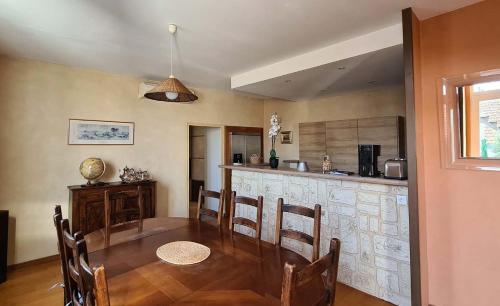 une salle à manger avec une table et une cuisine dans l'établissement Au Carpe Diem, à Châteauneuf-du-Pape