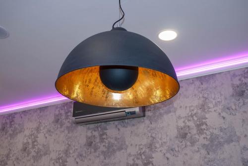 a black and gold pendant light hanging from a ceiling at Bornemisza Kúria Wellness Resort in Tiszabecs