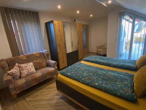 ein Schlafzimmer mit einem Bett und einem Sofa in der Unterkunft Ferienhaus Am Alten Kirchsteig in Helmbrechts