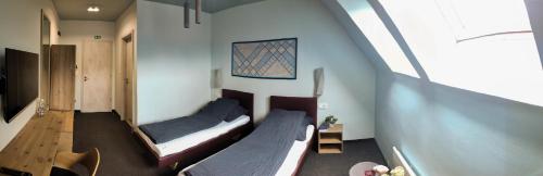a small room with two beds and a staircase at Bornemisza Kúria Wellness Resort in Tiszabecs