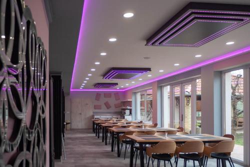 a row of tables and chairs in a room with purple lighting at Bornemisza Kúria Wellness Resort in Tiszabecs