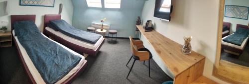 a room with three beds and a table and chairs at Bornemisza Kúria Wellness Resort in Tiszabecs