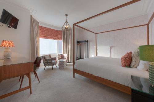 1 dormitorio con cama, escritorio y silla en Florence Suite Boutique Hotel and Restaurant, en Portsmouth