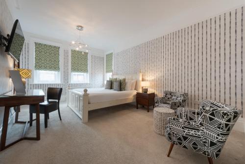 1 dormitorio con 1 cama y escritorio en una habitación en Stattons Boutique Hotel & Restaurant, en Portsmouth