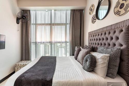 Amani Luxury Apartments Nairobi في نيروبي: غرفة نوم بسرير كبير مع نافذة كبيرة