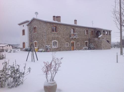a large brick building in the snow at Masseria Fontana dei Fieri in Pietrelcina