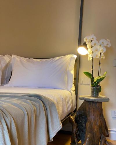 a bedroom with a bed and a table with a vase of flowers at Tenuta Pizzone Wine Resort in Rivanazzano