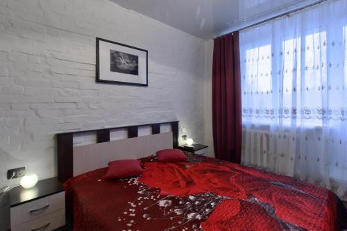 een slaapkamer met een rood bed en een raam bij EvroApartment on Moskovskaya in Sint-Petersburg