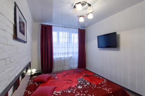 a bedroom with a red bed and a window at EvroApartment on Moskovskaya in Saint Petersburg