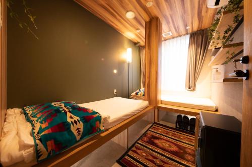 a small bedroom with a bed and a window at Glamping Tokyo Asakusa in Tokyo