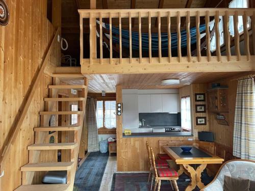 a wooden cabin with a loft bed and a kitchen at Chalet Kuckuk in Habkern