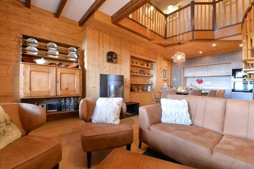 un salon avec un canapé et des chaises et une cuisine dans l'établissement LES GÎTES D'ADELSPACH - Gîtes 4 étoiles Nature & Spa, à Aubure