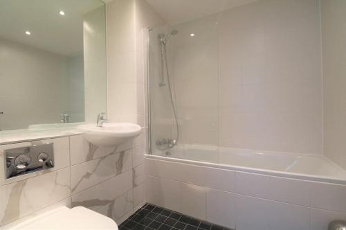 a bathroom with a toilet and a sink and a shower at Lovely Modern Central & Spacious in Liverpool