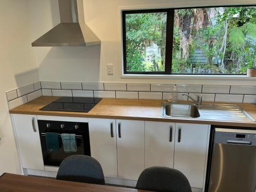 a kitchen with a sink and a stove and a window at Kea Retreat in Franz Josef