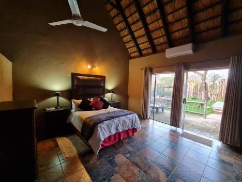 - une chambre avec un lit et un ventilateur de plafond dans l'établissement Leopard Rock Guest Lodge, à Mica
