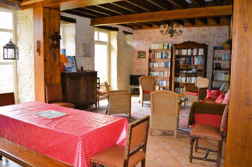 comedor con mesa, sillas y libros en La Quinta, belle maison en pierres avec jardins, en Asnelles