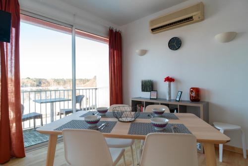 une salle à manger avec une table et des chaises et un balcon dans l'établissement France - Appt pour 4 proche plage, à Bénodet