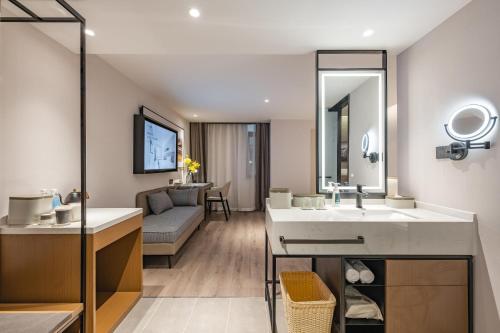 a bathroom with a sink and a living room at Atour Hotel Chengdu Taikoo Li Chunxi Road Pedestrian in Chengdu