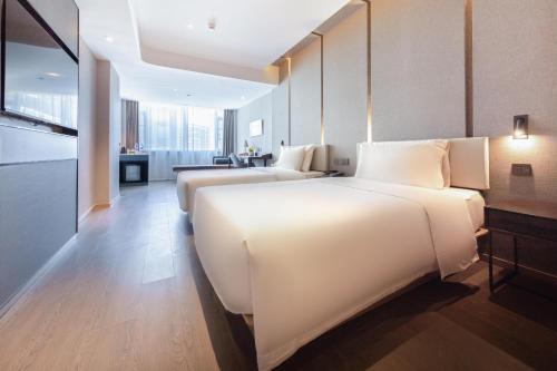 een grote witte slaapkamer met 2 bedden. bij Atour Hotel Shenzhen Baoan International Convention and Exhibition Center in Bao'an