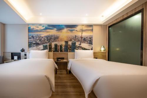 twee bedden in een hotelkamer met een schilderij aan de muur bij Atour Hotel Shanghai Lujiazui Babaihan in Shanghai