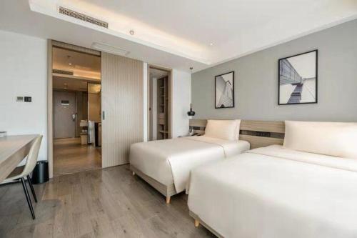 een hotelkamer met 2 bedden en een bureau bij Atour Hotel Suzhou Railway Station North Square Bole Shi in Suzhou