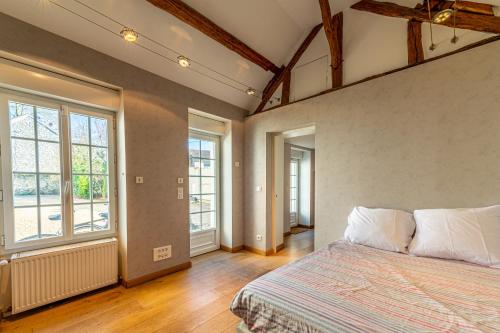 een slaapkamer met een bed en 2 ramen bij Domaine de Jade - Maison de Maître pour 15 in Châtillon-la-Borde
