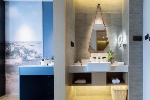 a bathroom with two sinks and a mirror at Atour Hotel Xiamen Lianban Mingfa Plaza in Xiamen