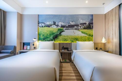 two beds in a room with a painting on the wall at Atour Hotel Hongqiao Hub National Exhibition Center Shanghai in Shanghai