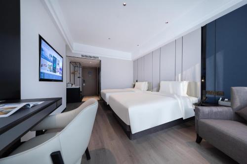 a hotel room with two beds and a tv at Atour X Hotel Ningbo Railway Station Liuting Street in Ningbo